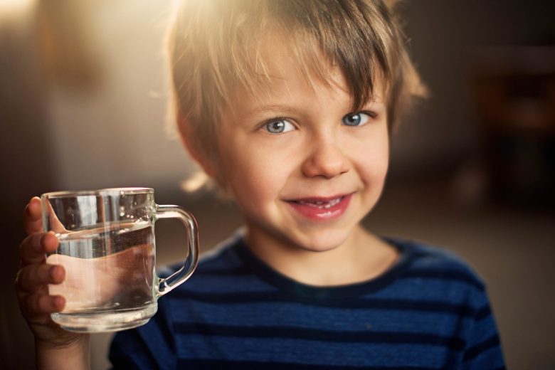 Ways to get your kids to drink more water: A boy and his water, Source: iStockPhoto via Amelia Johnson ways to get your kids to drink more water