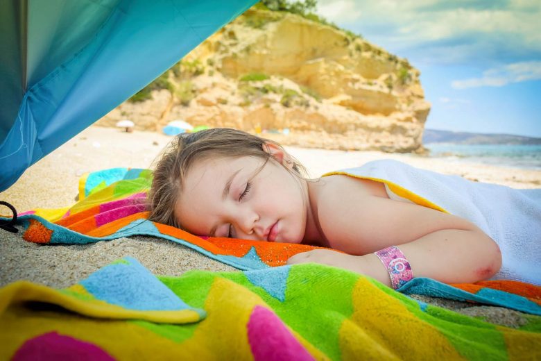 Girl sleeping on a beach, Source: Pixabay taking your kids on vacation