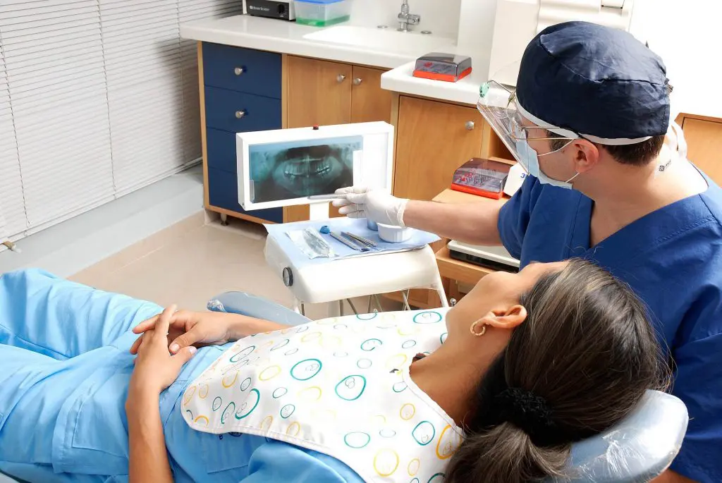 Patient looking at x-rays in a dentist chair, Source: Pixabay overbite and its effect to your oral health